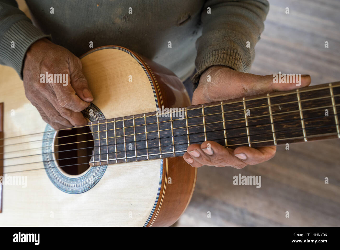 Hände eines ecuadorianischen Gitarrenbauer hält eine fertige Konzertgitarre in San Bartolome Stockfoto