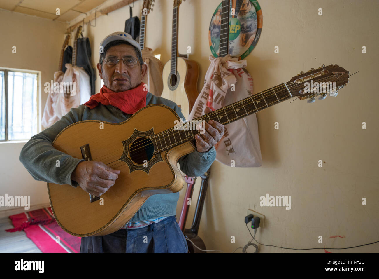 22. Juli 2016 San Bartolome, Ecuador: Gitarrenbauer Mann stehend mit einer fertigen Konzertgitarre in seinem Geschäft Stockfoto