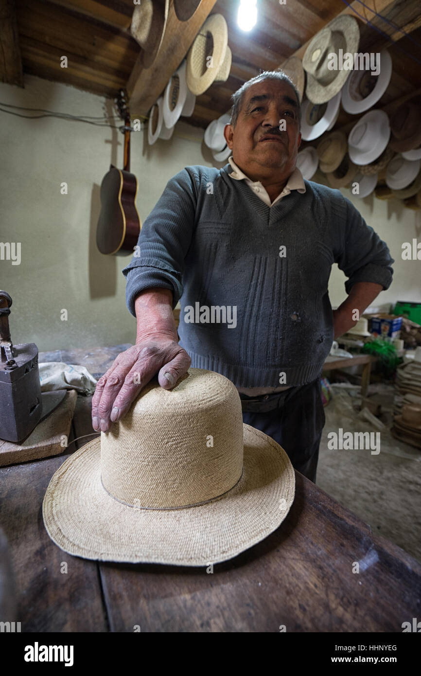22. Juli 2016 San Bartolome, Ecuador: ein Strohhut Maker Mann ruht seine Hand über einen neuen Hut Stockfoto