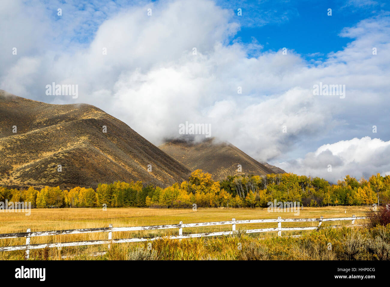 Zaun und Berg unter Wolken Stockfoto