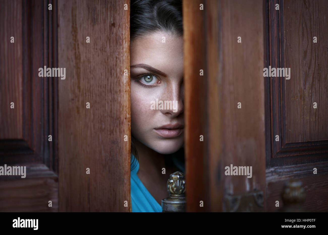 Kaukasische Frau spähen in Tür Stockfoto