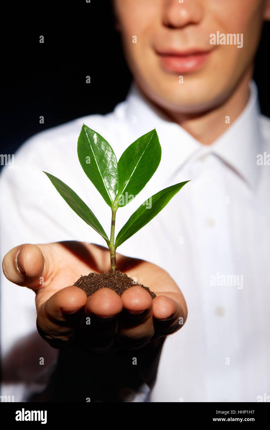 Vertikale Schuss ein lächelnder Mann mit einem zukünftigen Baum für Wiederaufforstungsprogramm Stockfoto