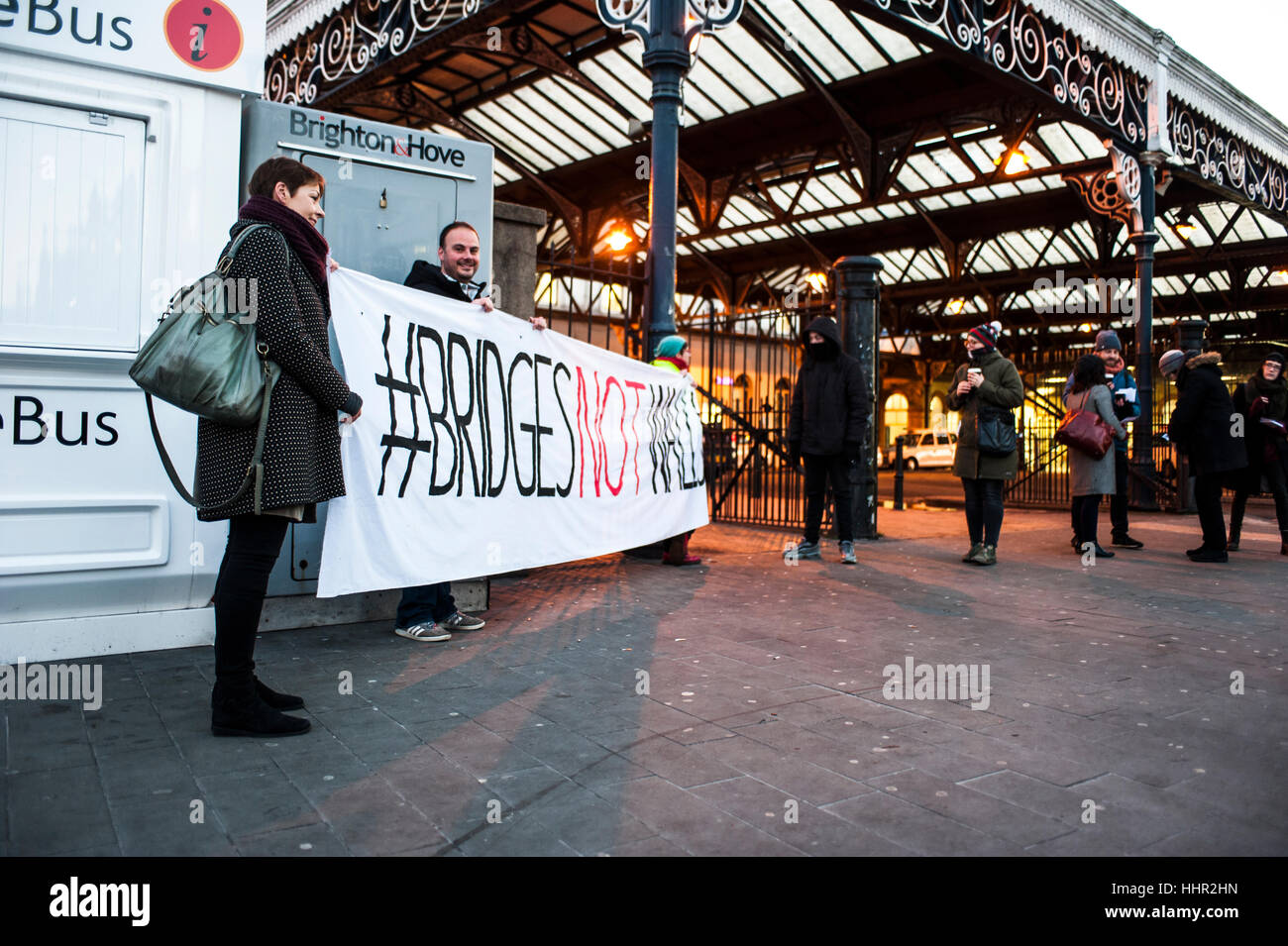 Brighton, England, Vereinigtes Königreich. 20. Januar 2017. Brighton, East Sussex. 20. Januar 2017. Hunderte von Aktivisten in ganz Großbritannien und dem Rest der Welt senden eine friedliche Botschaft der Hoffnung und der Einheit mit Präsident Donald Trump Einweihung zusammenfallen. Die #BridgesNotWalls-Bewegung wurde von Trump es Wahl versprechen, eine Mauer zwischen den USA und Mexiko inspiriert. Im Bild; Lesben und Schwule Unterstützung der Migranten auf außerhalb zum Bahnhof von Brighton zu überbrücken haben Banner entfernt, und mit Caroline Lucas MP vor Bahnhof. Bildnachweis: Francesca Moore/Alamy Live-Nachrichten Stockfoto