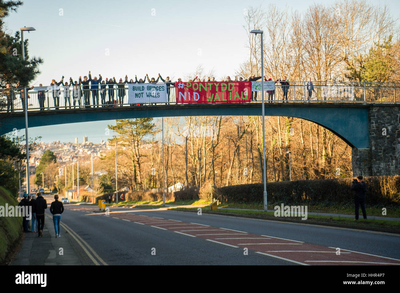 Freitag, 20. Januar 2017, Aberystwyth Wales UK bauen Brücken nicht Wände: um 11:00 am Freitag, 20. Januar 2017 Menschen enthüllen Banner auf der Fußgängerbrücke über die Hauptstraße in Aberystwyth als Bestandteil der UK-weiten Banner Tropfen aus Brücken quer durch das Land, am Tag, die Donald Trump ist zum neuen Präsidenten der Vereinigten Staaten eröffnet.    Nach Angaben der Organisatoren, sie wollen ", eine einfache, hoffnungsvolle und unverwechselbare Nachricht senden. Wir bauen Brücken, keine Mauern, zu einer friedlicheren und gerechteren Welt von Unterdrückung und Hass zu befreien."   Foto: Keith Morris / Alamy Live NewsBuo Stockfoto