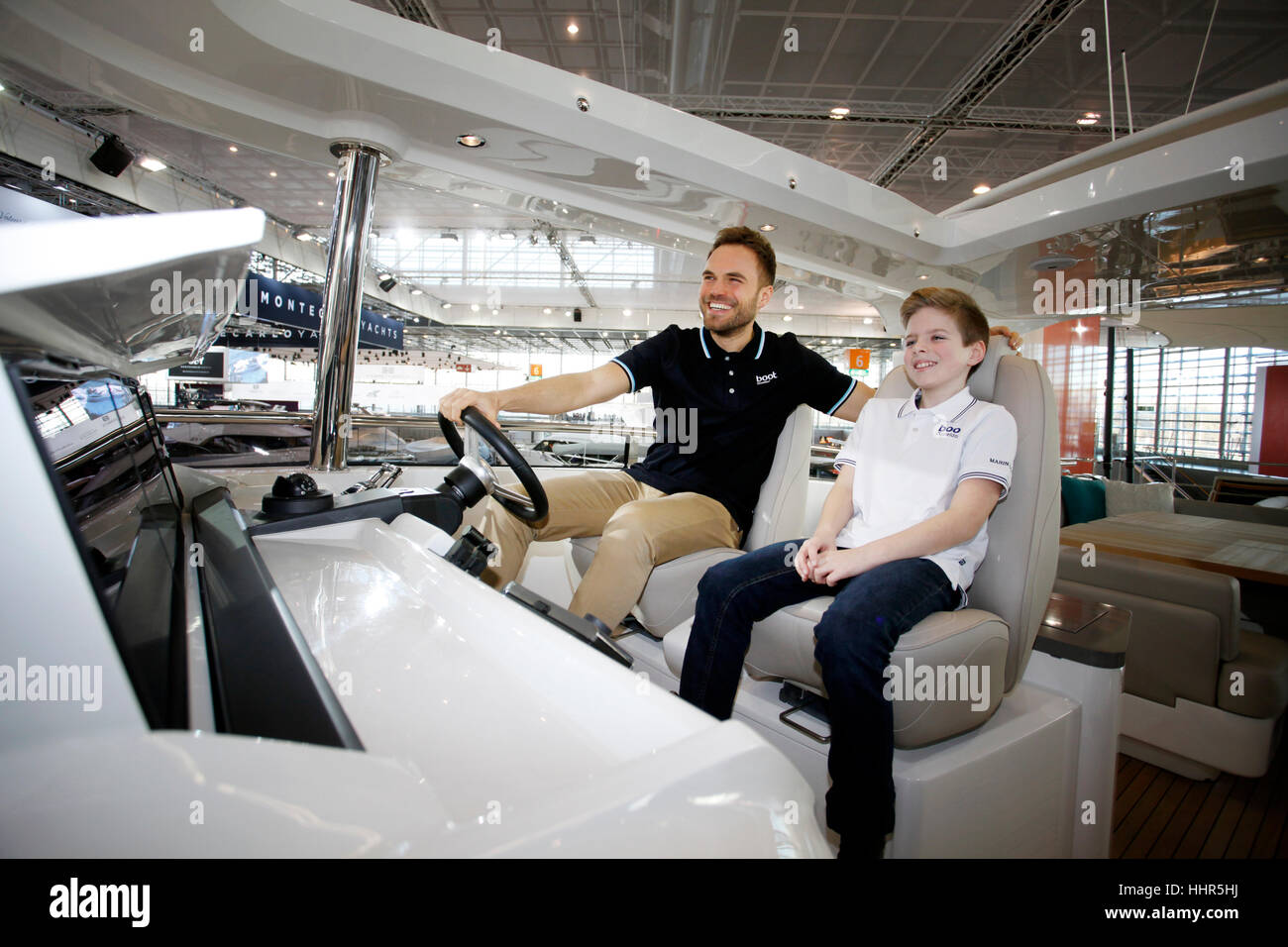 Boot Düsseldorf 2017 - die weltweit größte Segel- und Wasser Sport-Ausstellung.  Der Star ist die Prinzessin 30M, die größte und teuerste Luxusyacht auf der Messe. Stefan und Daniel (junge) am Lenkrad. Stockfoto