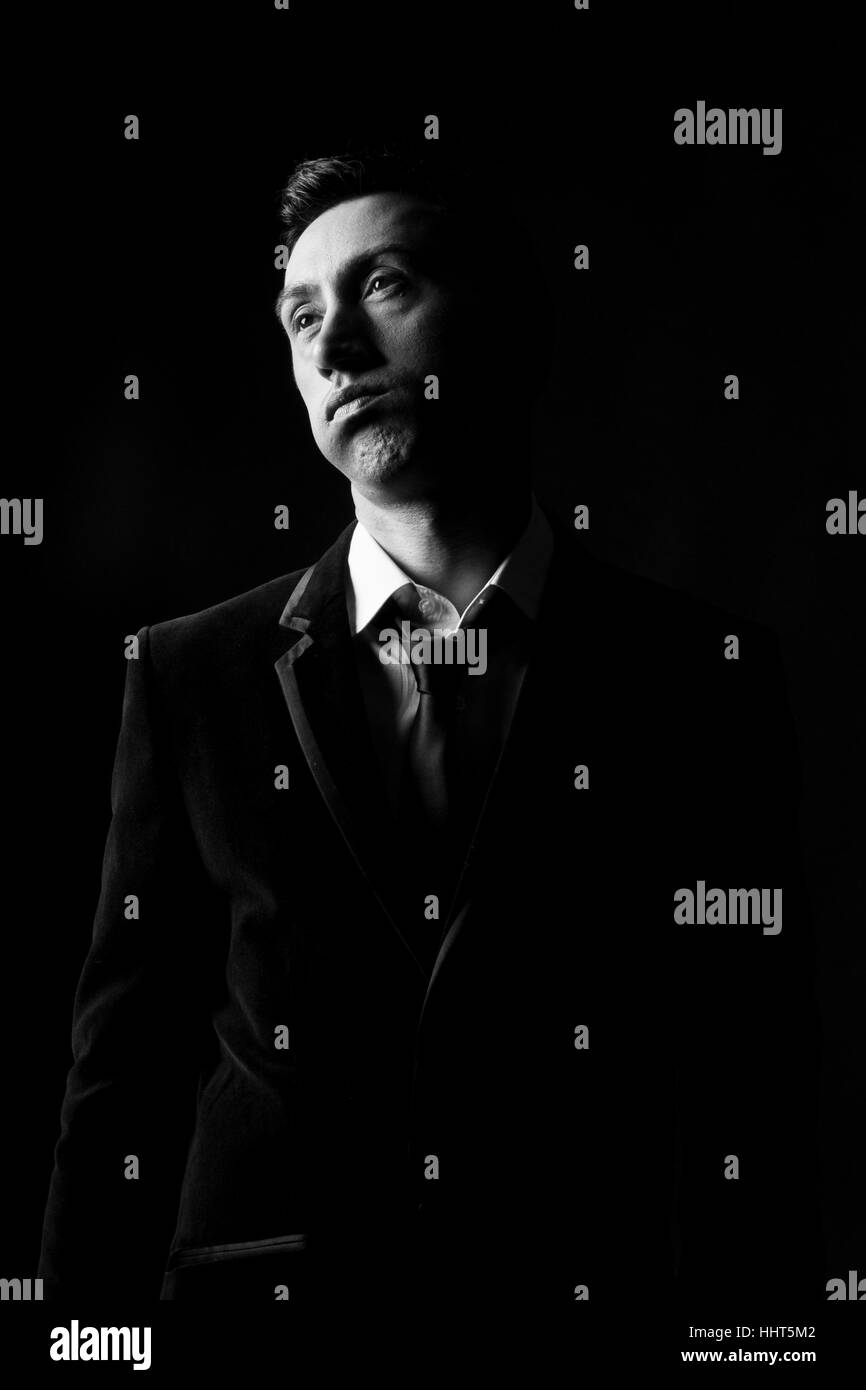 Portrait der Mann in den Dreißigern schnaubend auf schwarzem Hintergrund Stockfoto