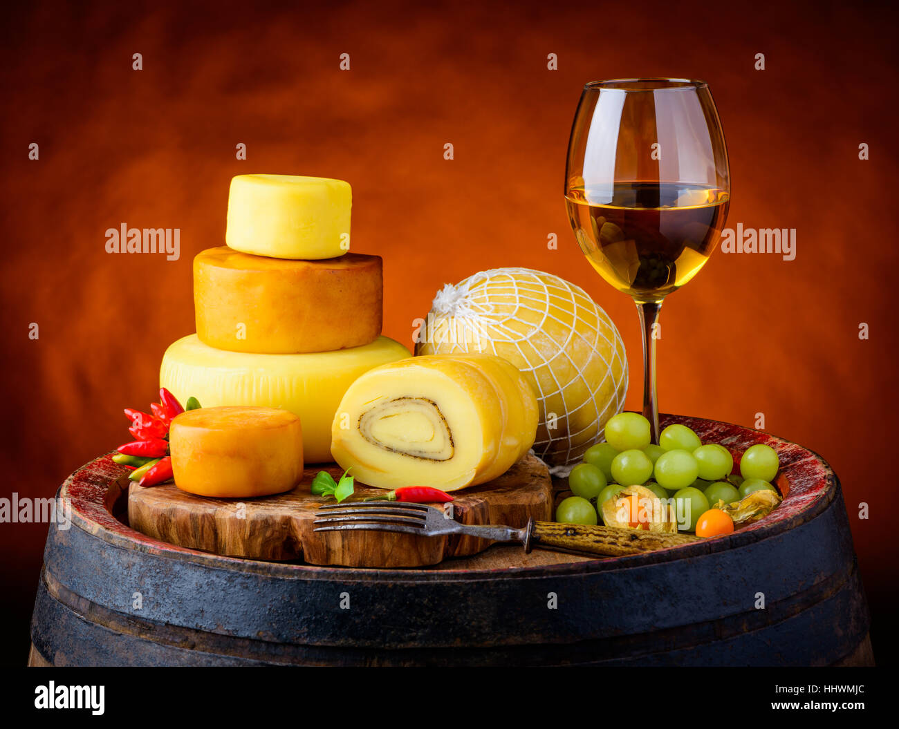 Glas Weißwein mit Käse Zuhälterei, geräuchert und komplettes Käse in Vintage Stillleben Stockfoto