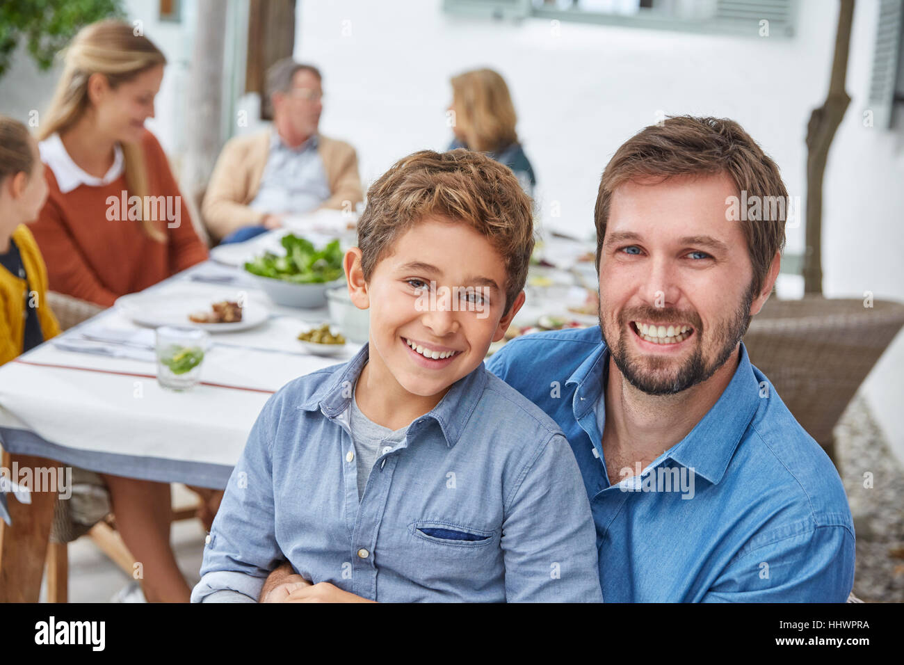 Porträt begeisterten Vater und Sohn genießen Terrasse Mittagessen Stockfoto