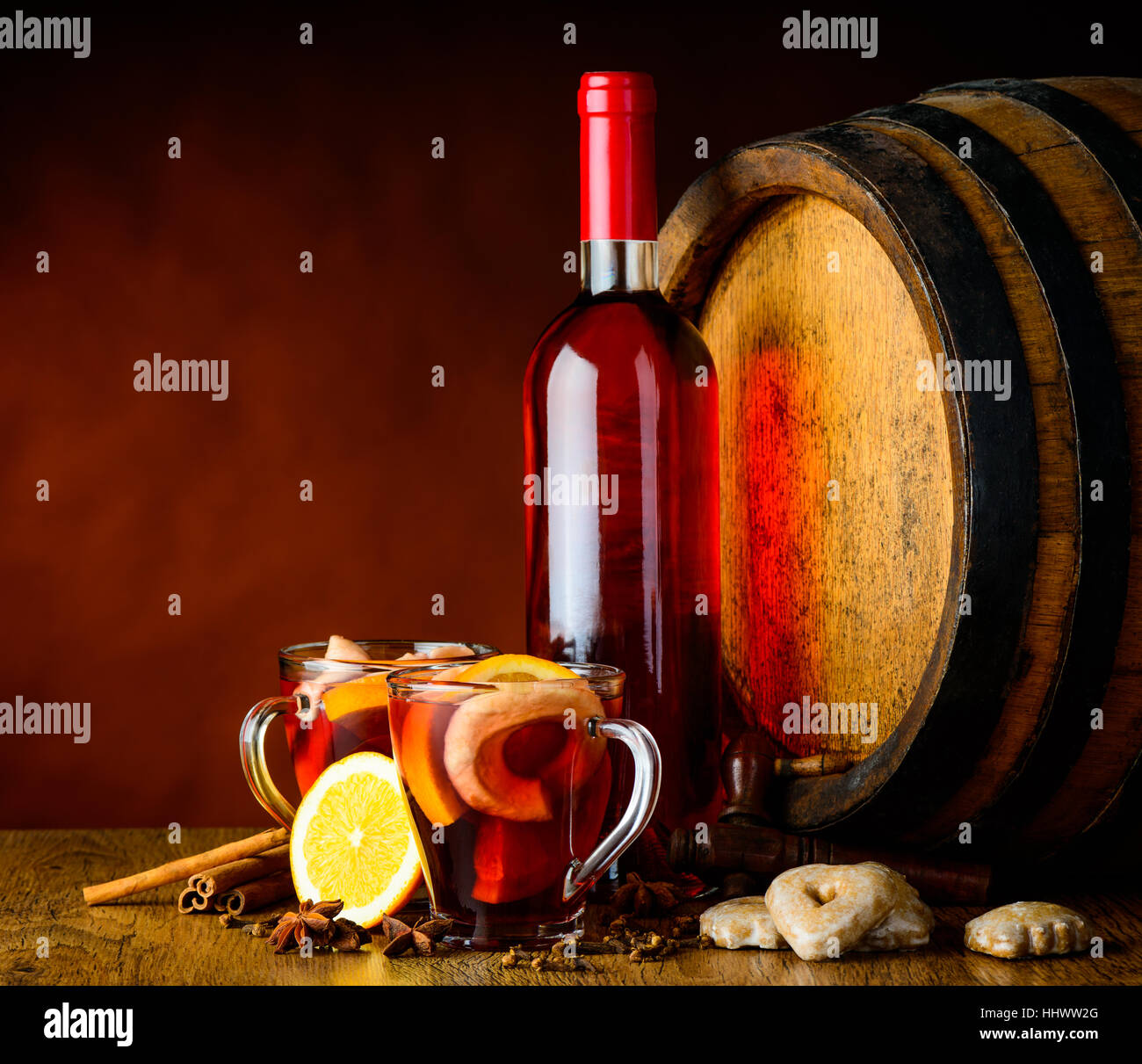 Glühwein in Stillleben mit Glas, Flasche, Fass und Gewürzen in einem rustikalen Keller Stockfoto