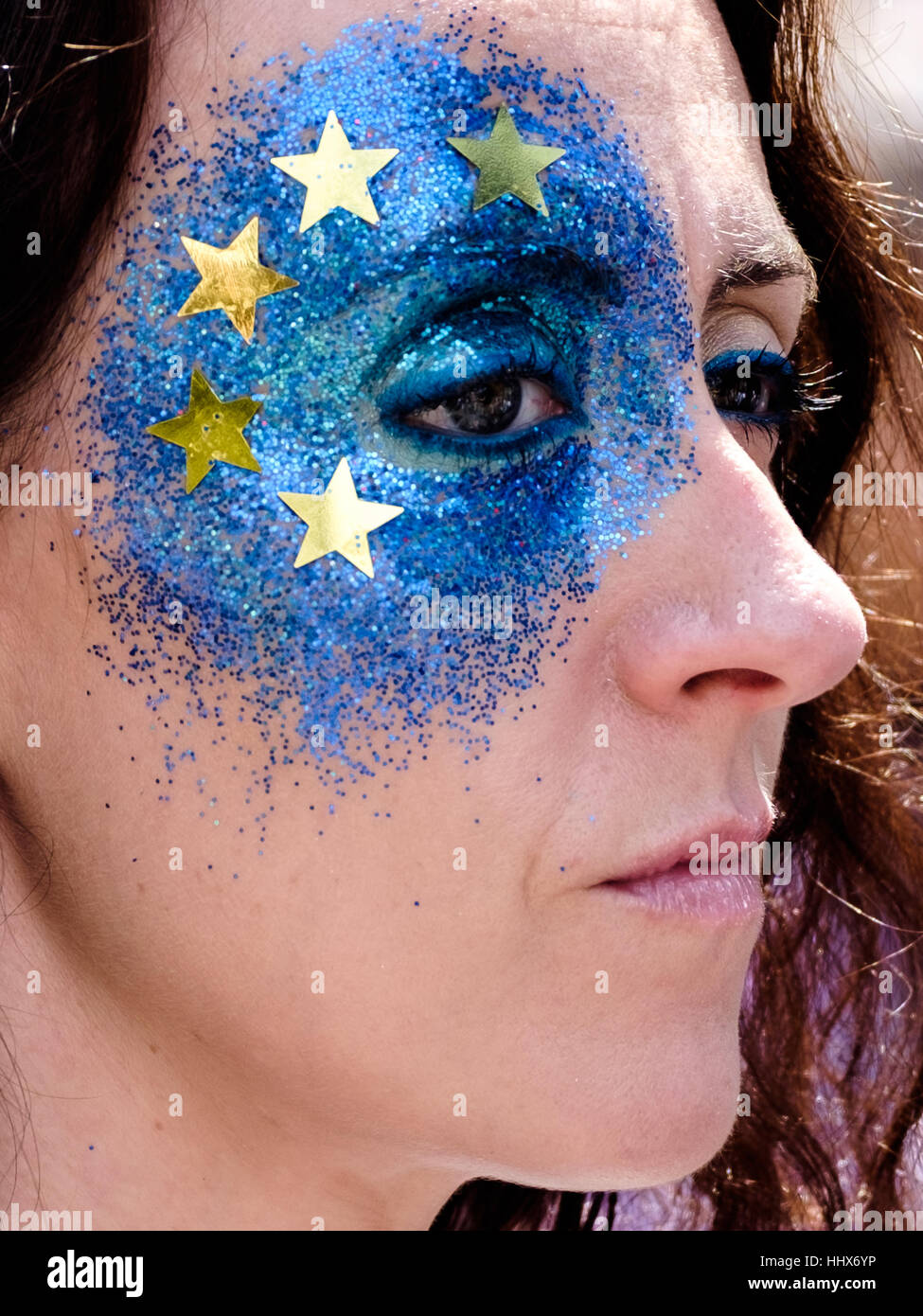 Frau mit glitzernden EU-Flagge gemalt auf ihrem Gesicht. Stockfoto