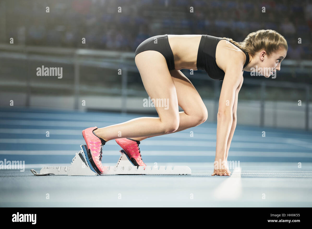 Sportplatz fokussiert am Startblock weibliche Läufer Stockfoto