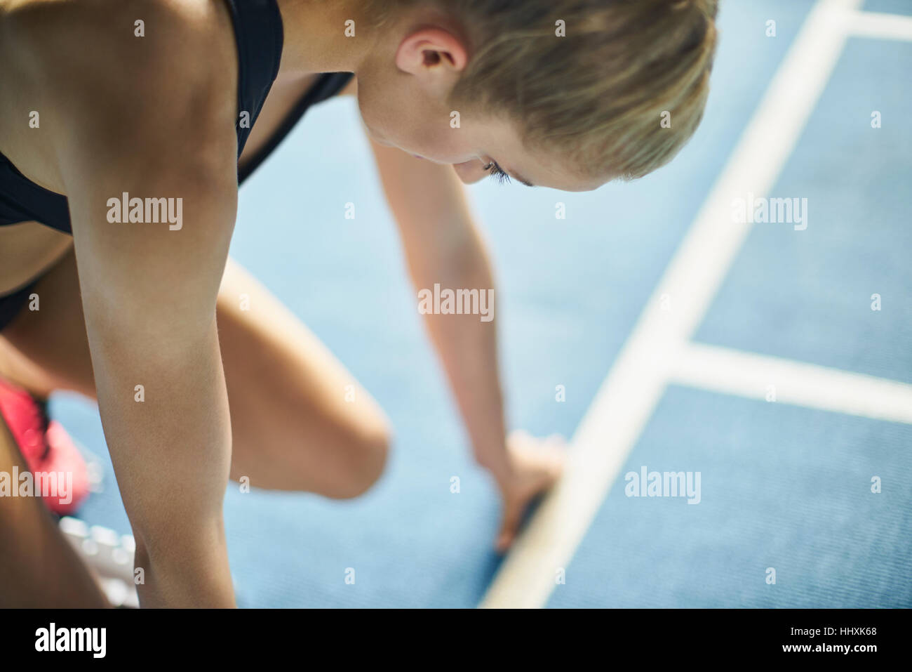 Sportplatz fokussiert am Startblock weibliche Läufer Stockfoto