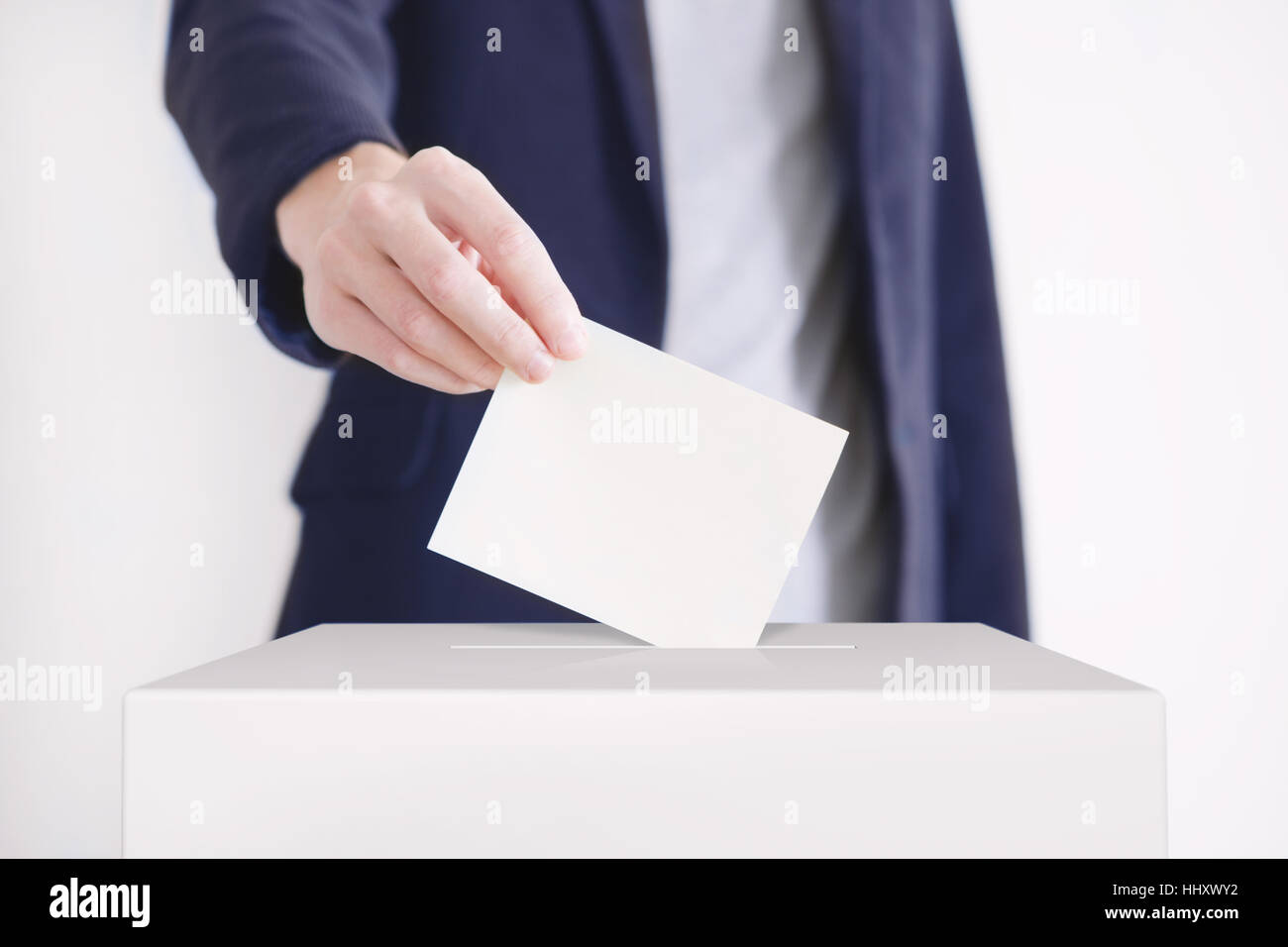 Mann, der einen Stimmzettel in eine Abstimmung Box. Stockfoto