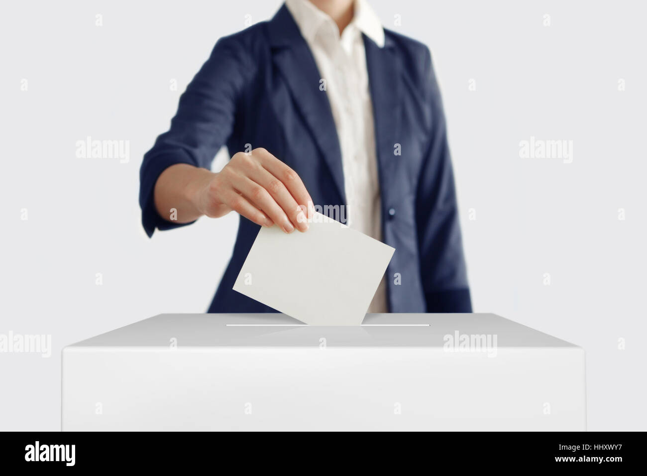 Frau einen Stimmzettel in eine Abstimmung Box setzen. Stockfoto