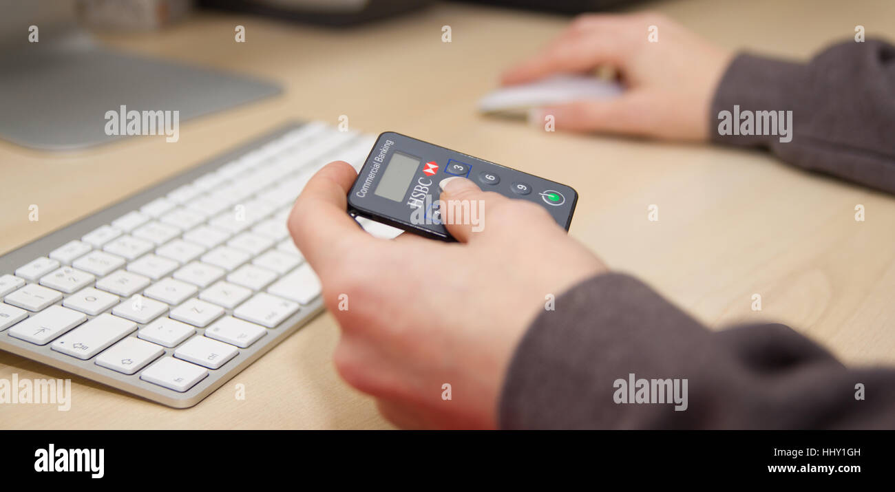 Preston, England 01.12.2017 Frau HSBC Login Gerät halten. Sie wird sich sicher auf die Banking-Website anmelden. Stockfoto