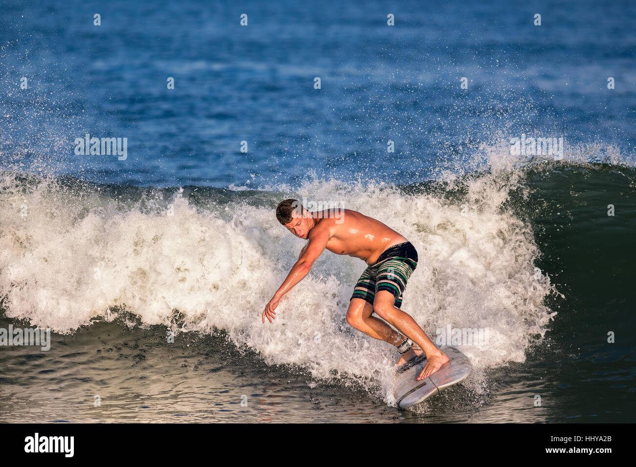 Ein junger Mann in seinen frühen 20er Jahren surfen. Er hat eine Welle im Atlantischen Ozean gefangen. Die Lage ist die New Jersey Shore. Stockfoto