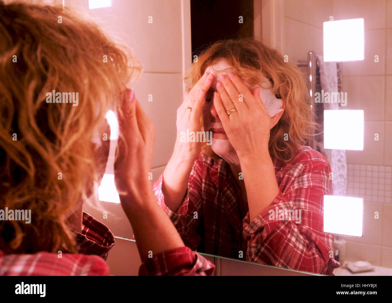 Reife Mitte Alter Frau tragen eine Schönheit Maske Gesichtsmaske, alternde Haut zu helfen Stockfoto