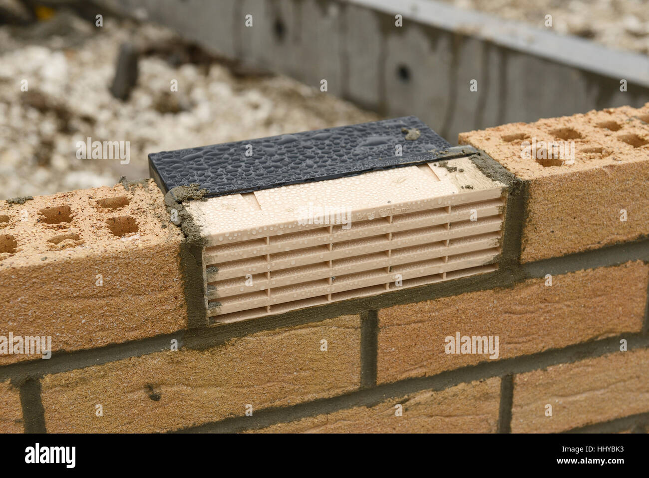 Kunststoff-Entlüfter-Ziegel in der teilweise gebauten Mauer eines Hauses Stockfoto