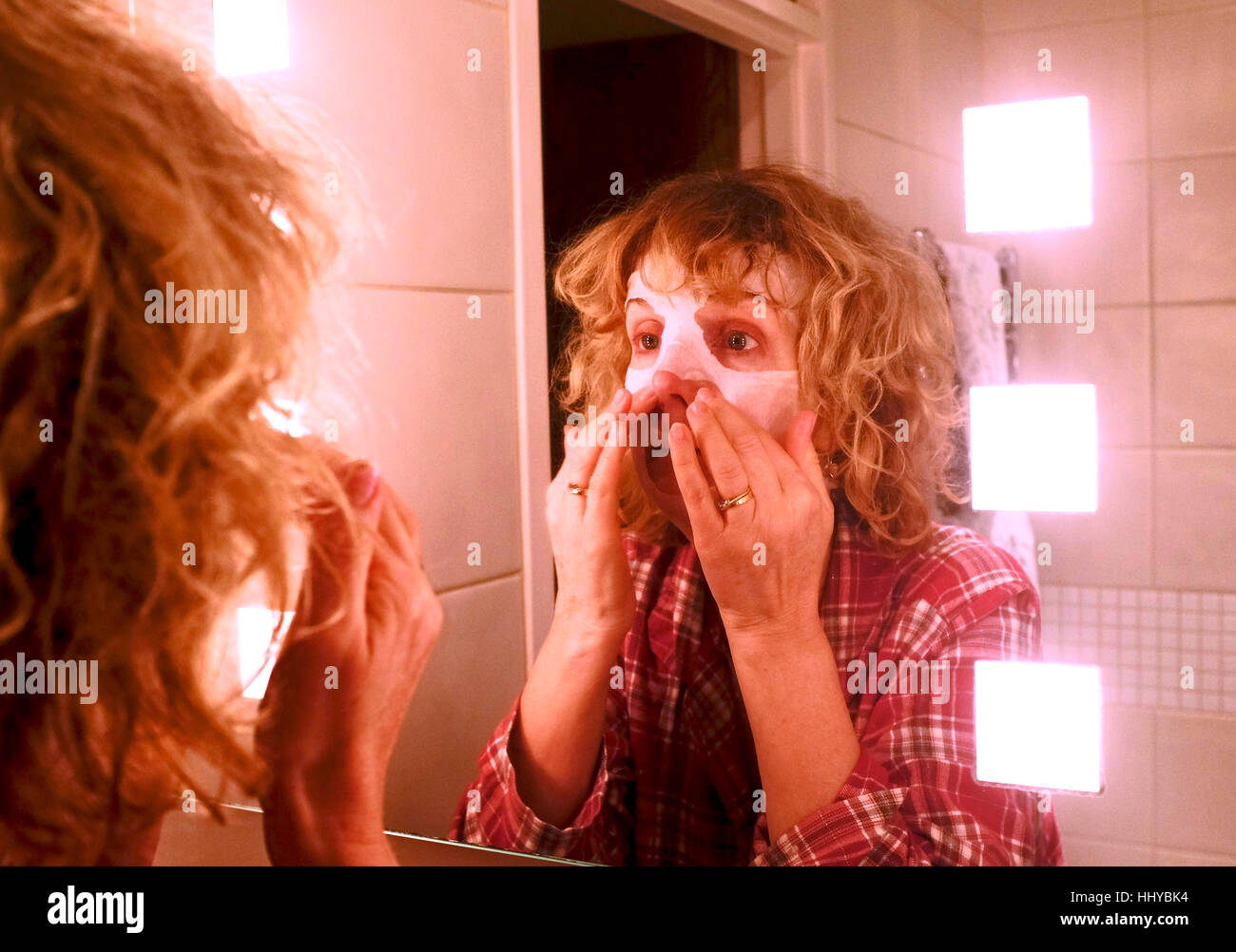 Reife Mitte Alter Frau tragen eine Schönheit Maske Gesichtsmaske, alternde Haut zu helfen Stockfoto