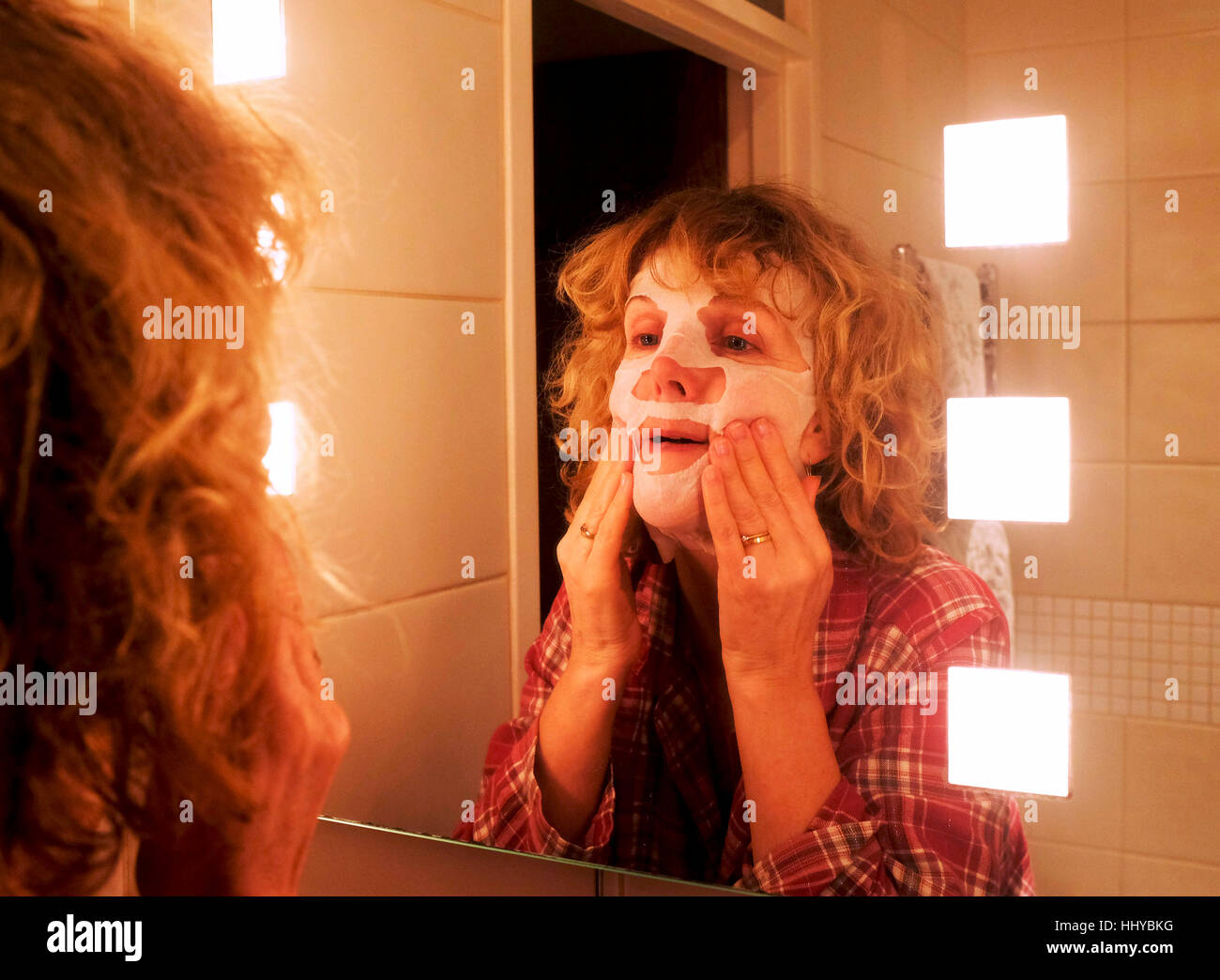 Reife Mitte Alter Frau tragen eine Schönheit Maske Gesichtsmaske, alternde Haut zu helfen Stockfoto