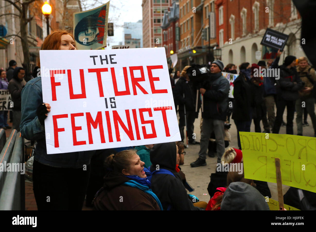Washington DC, USA. Januar 20, 2017. Demonstrationen nutzen direkte Aktionen, die ein Sit-in abhalten, um einen Sicherheitskontrollpunkt in die Trump-Einweihungsparade zu blockieren. Eine Frau trägt ein Zeichen: "Die Zukunft ist feministisch". Stockfoto