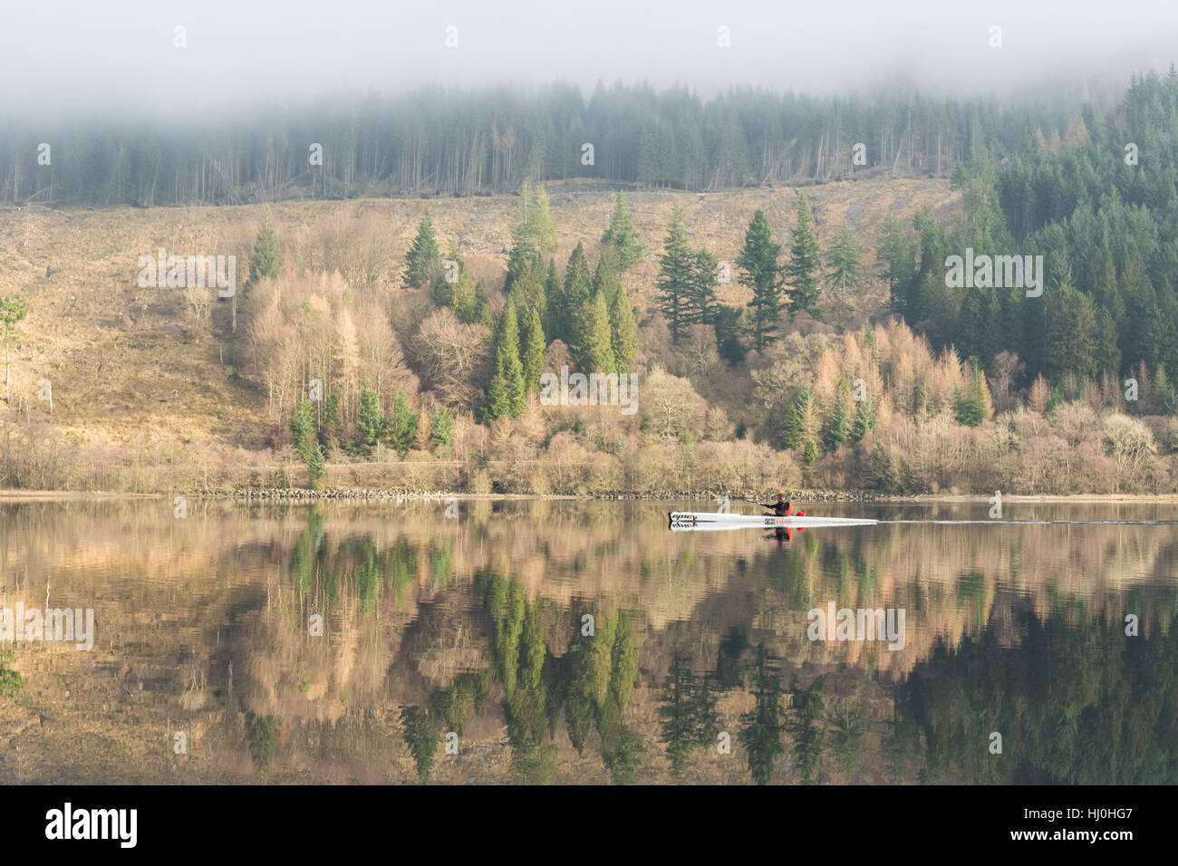 Callander, Loch Lomond & Trossachs National Park, Schottland - 21. Januar 2017: UK Wetter - ein Kajakfahrer spiegelt sich in das Stille Wasser des Loch Lubnaig auf einen schönen Atmostpheric Wintertag, als die Sonne kämpft sich durch dichten Nebel Kredit zu brechen: Kay Roxby/Alamy Live News Stockfoto