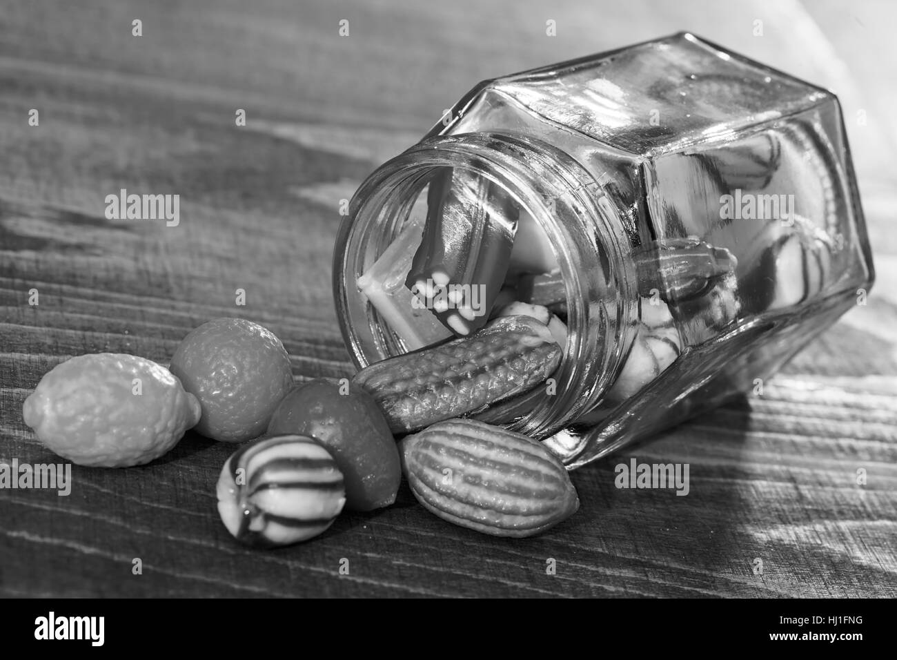 bunte Bonbons in ein Glas Jaron Holztisch, geringe Schärfentiefe Hinweis Stockfoto