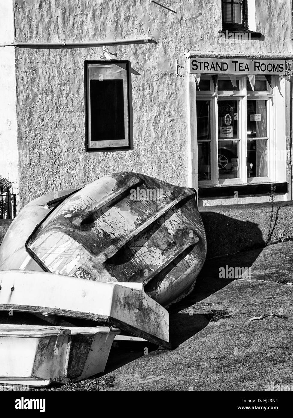 Umgedrehten Jollen an der Seite von einem Café namens ironisch "Strang Tea Rooms" Stockfoto