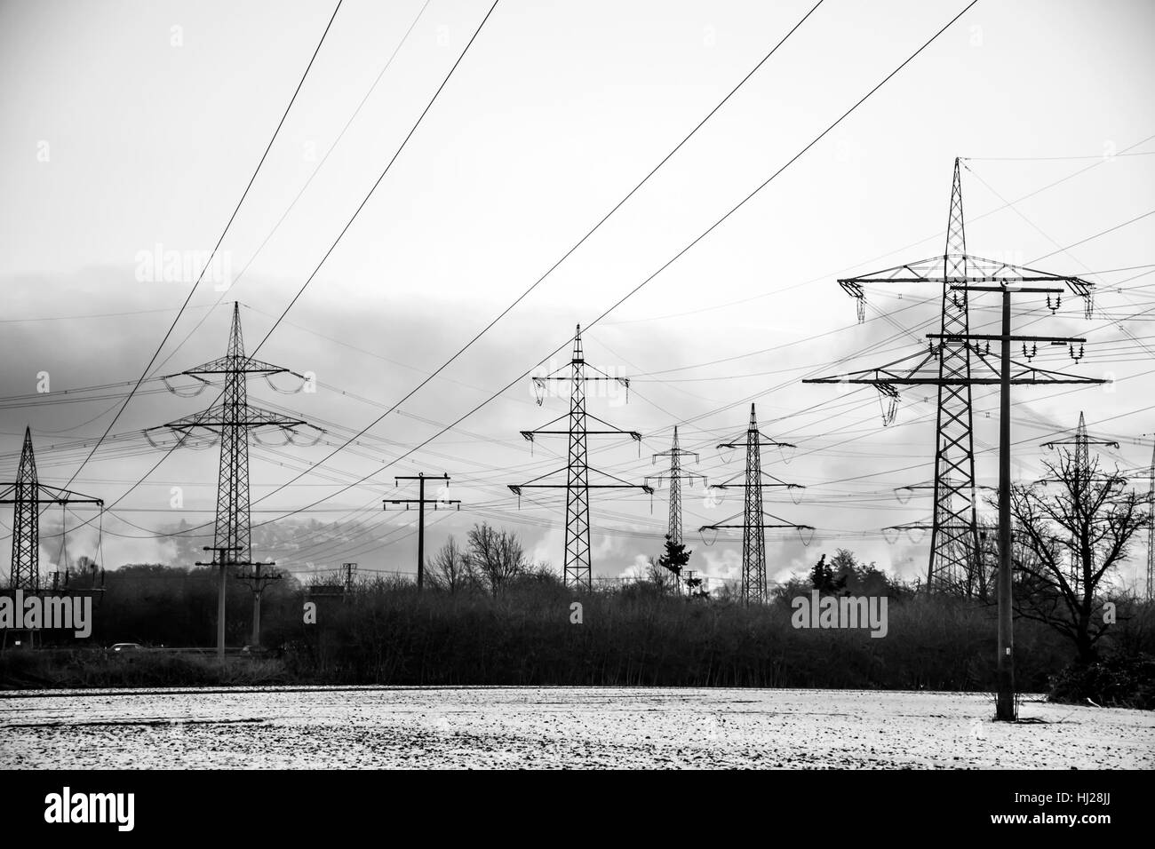 Elektrische Hochspannungsleitungen Winter Stahl Turm Landschaft Schnee schwarz weißen Sonnenauf- oder Sonnenuntergang Stockfoto