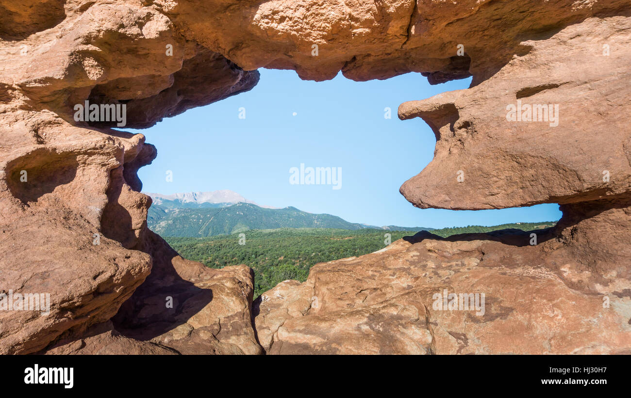 Blick auf den Mond und Pikes Peak durch die siamesische Zwillinge (eine benannte Felsformation) im Garten der Götter, Colorado Springs, Colorado. Stockfoto