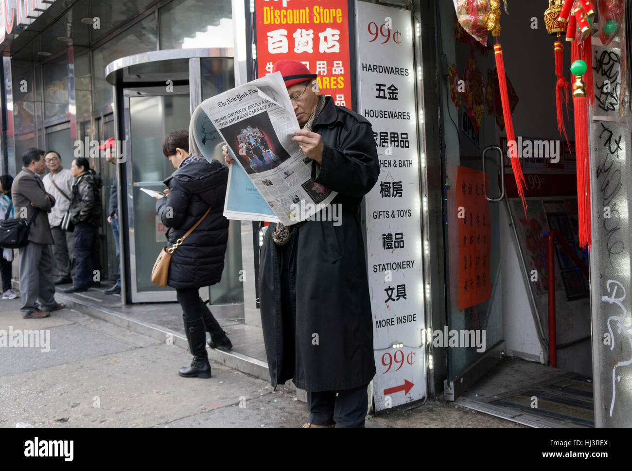 Eine asiatische Amerikaner lesen der New York Times am Morgen nach der Einweihung ist Trumpf. Chinatown, Flushing, Queens, New York. Stockfoto