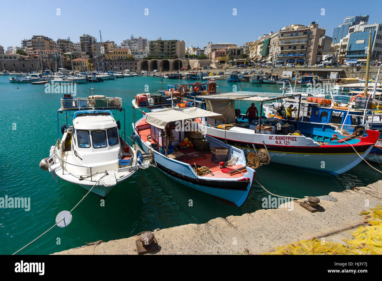 HERAKLION, Griechenland - 16. Juli 2016: Crete. Angelboote/Fischerboote im Hafen vor Anker. Im Hintergrund die Stadtteile. Stockfoto