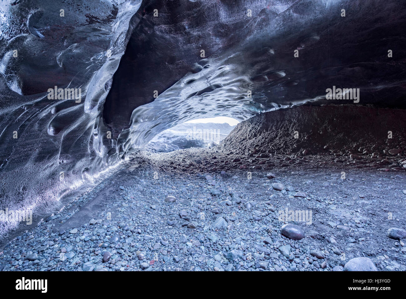 Eine vulkanische Eishöhle in Island nimmt die Farbe von den schwarzen vulkanischen Schmutz rund um den Gletscher aus dem die Höhle entstand Stockfoto