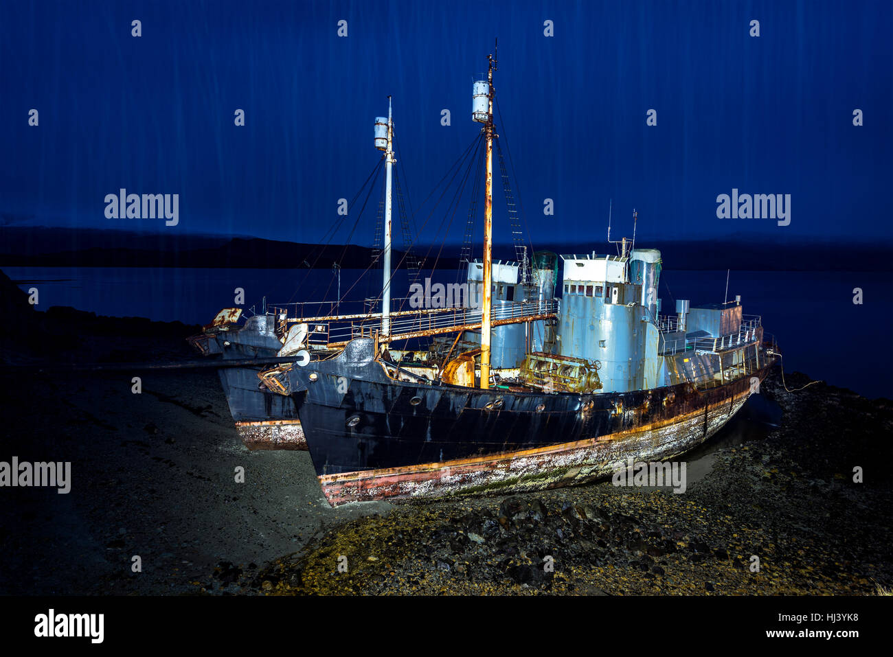 Zwei verlassene Walfang-Schiffe-Rest an einem einsamen Strand nach Island das Walfang Programm verschrottet. Schiffe sind Licht malte nachts mit starkem Regen gießen Stockfoto