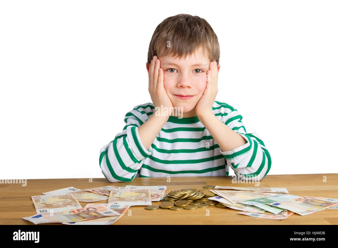 Junge sitzt vor eine Menge Geld Stockfoto