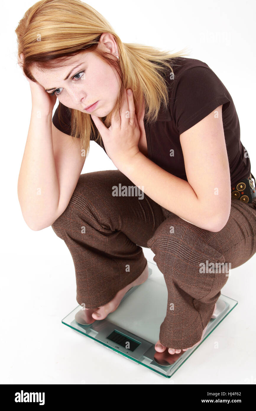 Frau, die ihr Gewicht auf einer Skala prüfen Stockfoto