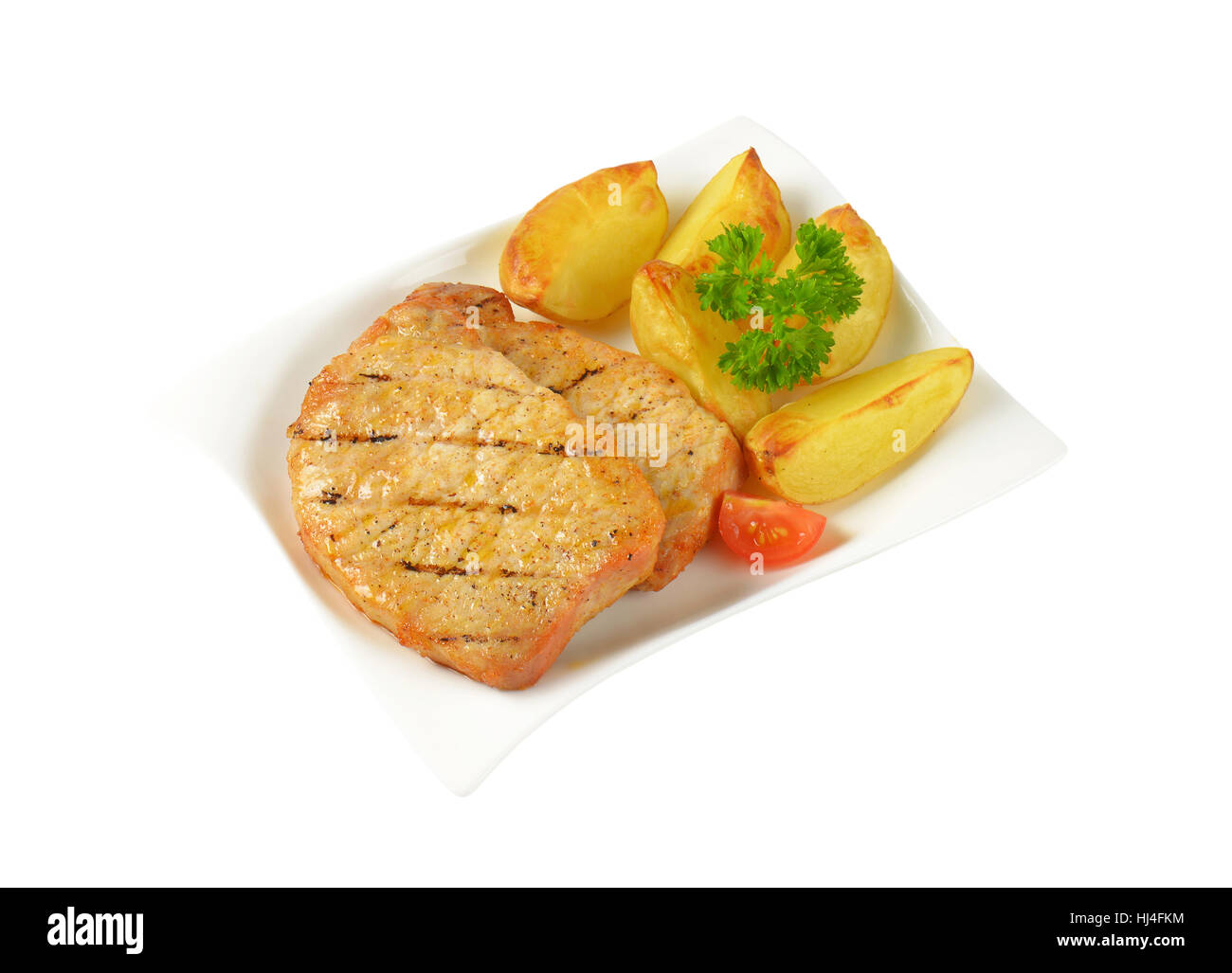 Gegrillte Honig glasierte Schweinekoteletts mit Kartoffelspalten Stockfoto