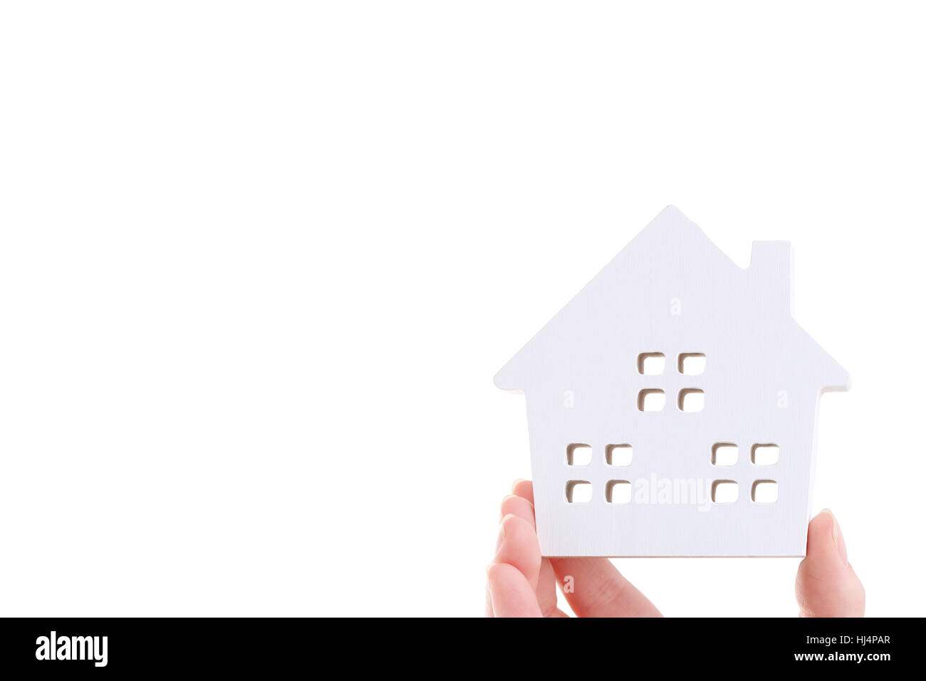 Hand hält Miniaturmodell des Hauses auf weißem Hintergrund Stockfoto