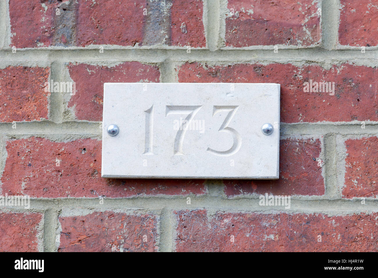 Haus Nummer 173 Zeichen auf roten Backsteinmauer Stockfoto