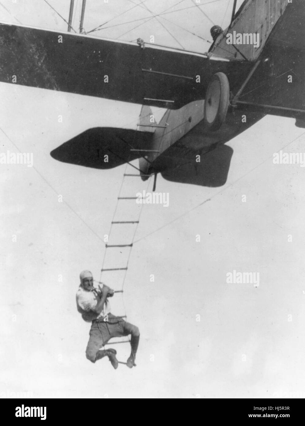 "Furchtloser Freddie", ein Hollywood-Stuntman, klammerte sich an einer Strickleiter aus einem Flugzeug geflogen von A.M. Maltrup, zu fallen in Automobil unten geschleudert: Automobil nicht angezeigt, ca. 1920 Stockfoto