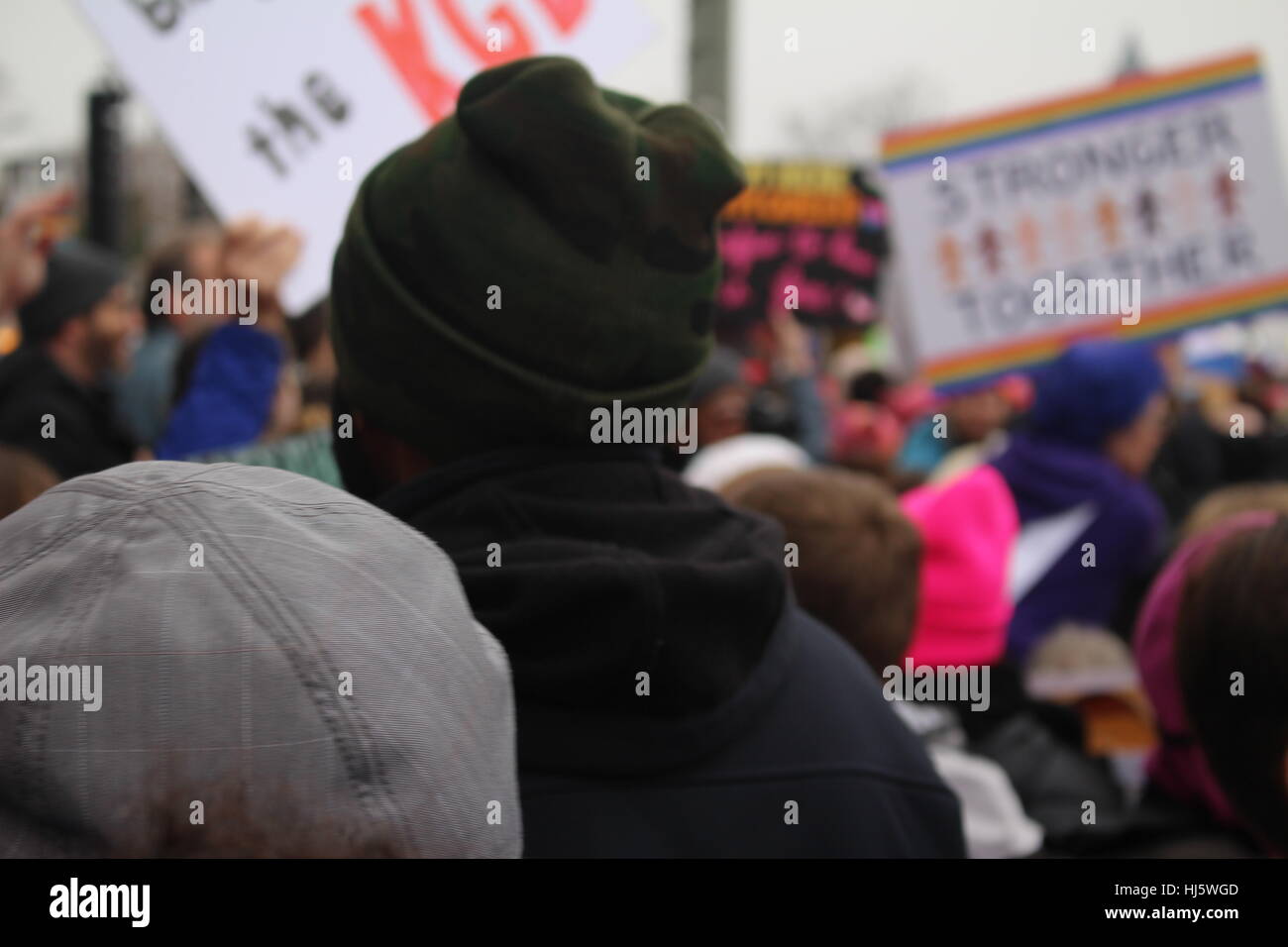 Distrikt von Columbia, USA. 21 Jan, 2017. Ein Mann schaut auf die Demonstranten auf der Constitution Avenue NW, das Washington Monument, das sich in der Ferne gesehen marschieren. Stockfoto
