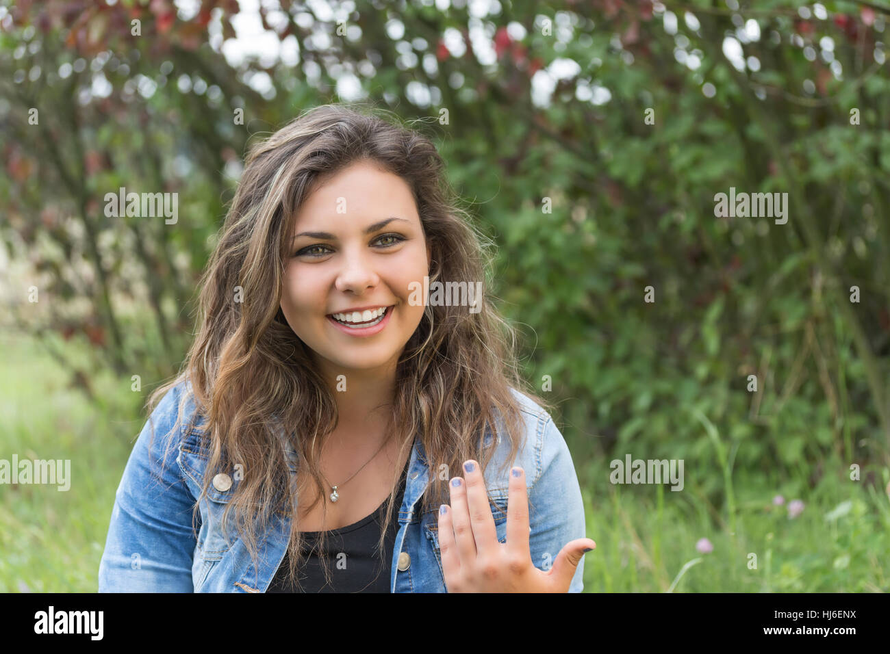 Attraktive Teenager-Mädchen lächelnd gestikulierend und schaut in die Kamera im Freien. Stockfoto