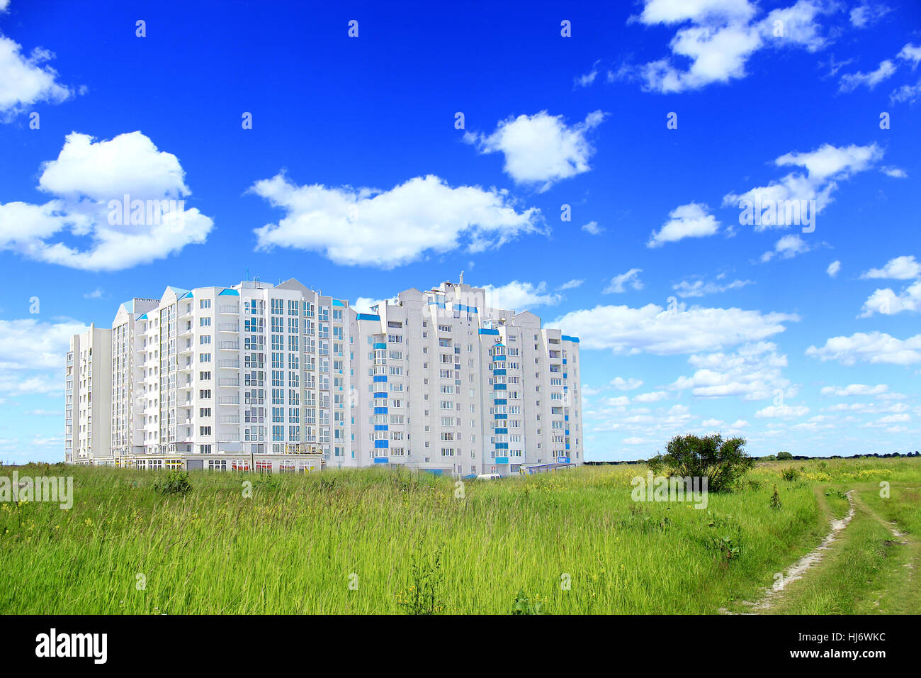 mehrstöckigen modernen Blocks in Feld mit grünem Rasen und Landstraße zu flach stehen Stockfoto