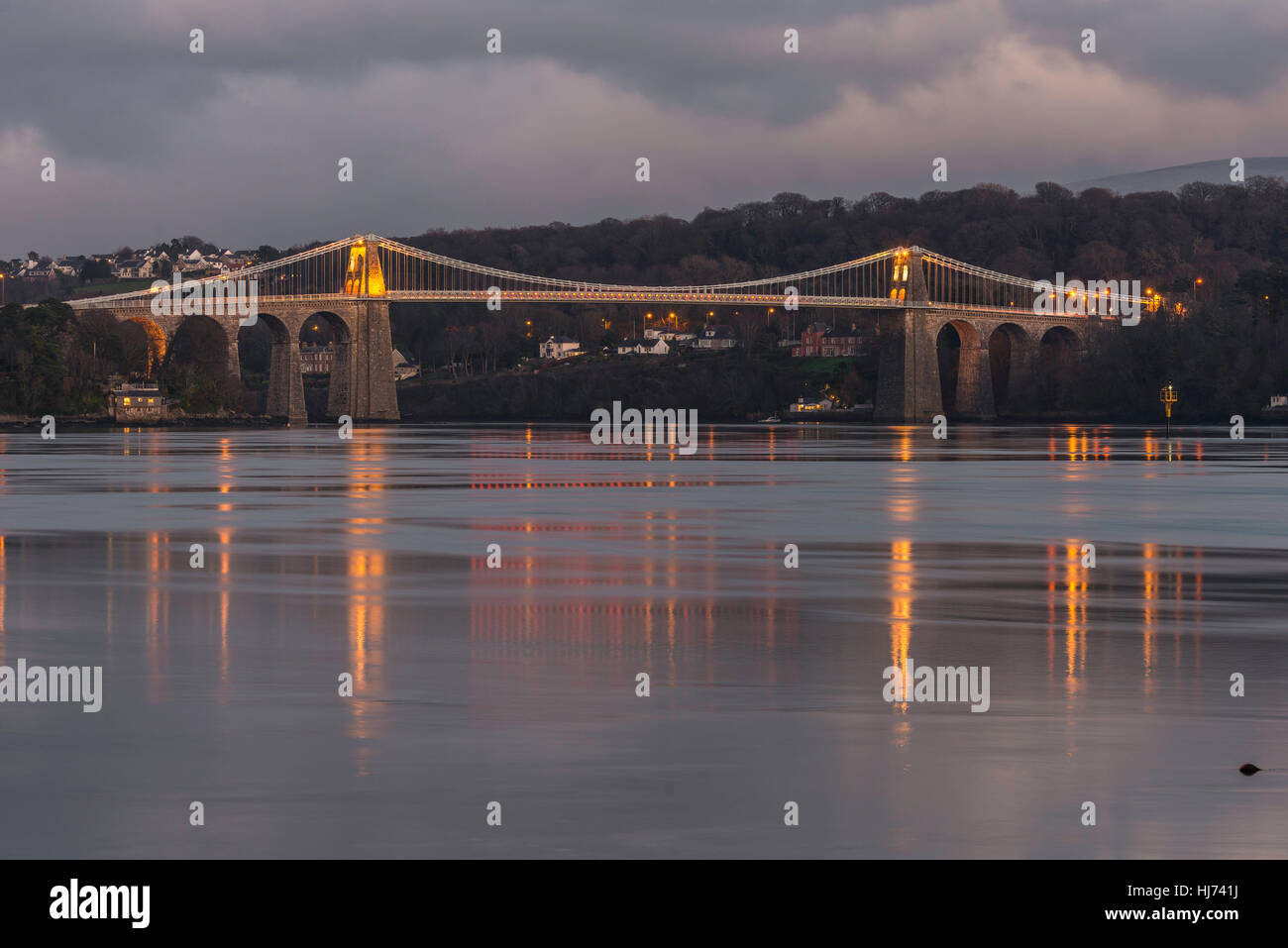 Menai Hängebrücke Anglesey North Wales Uk Landschaft. Nacht-Szene. Reflexionen, Rock, Lichter. Stockfoto