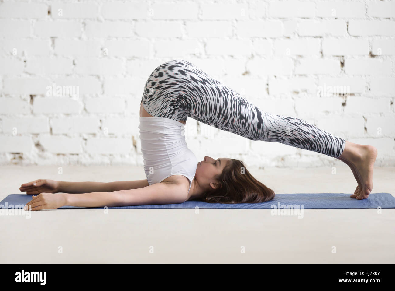 Junge attraktive Frau in Halasana pose, weiße Studio-Hintergrund Stockfoto