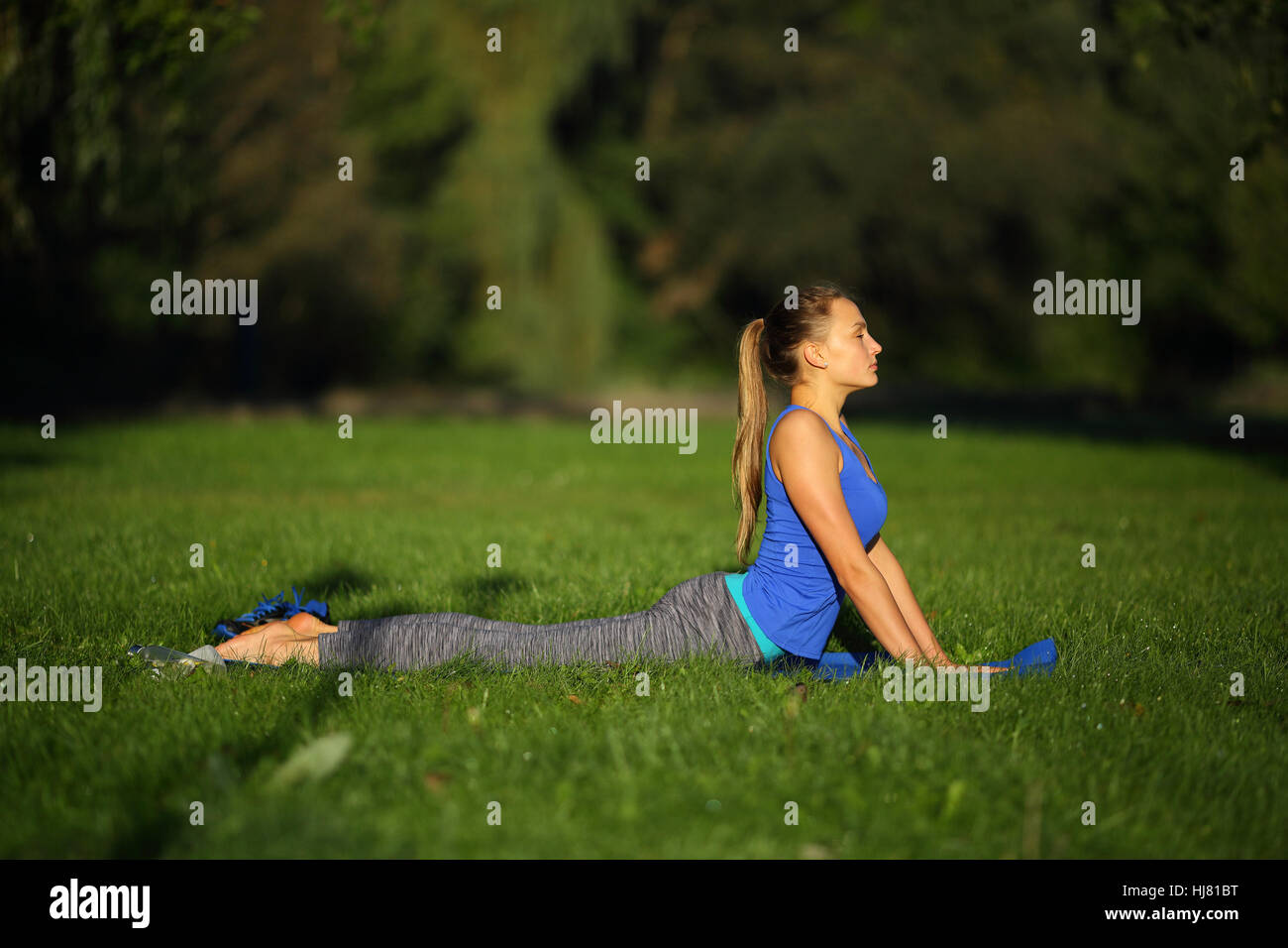 Schöne junge Frau in der Yoga-Cobra pose im freien Stockfoto