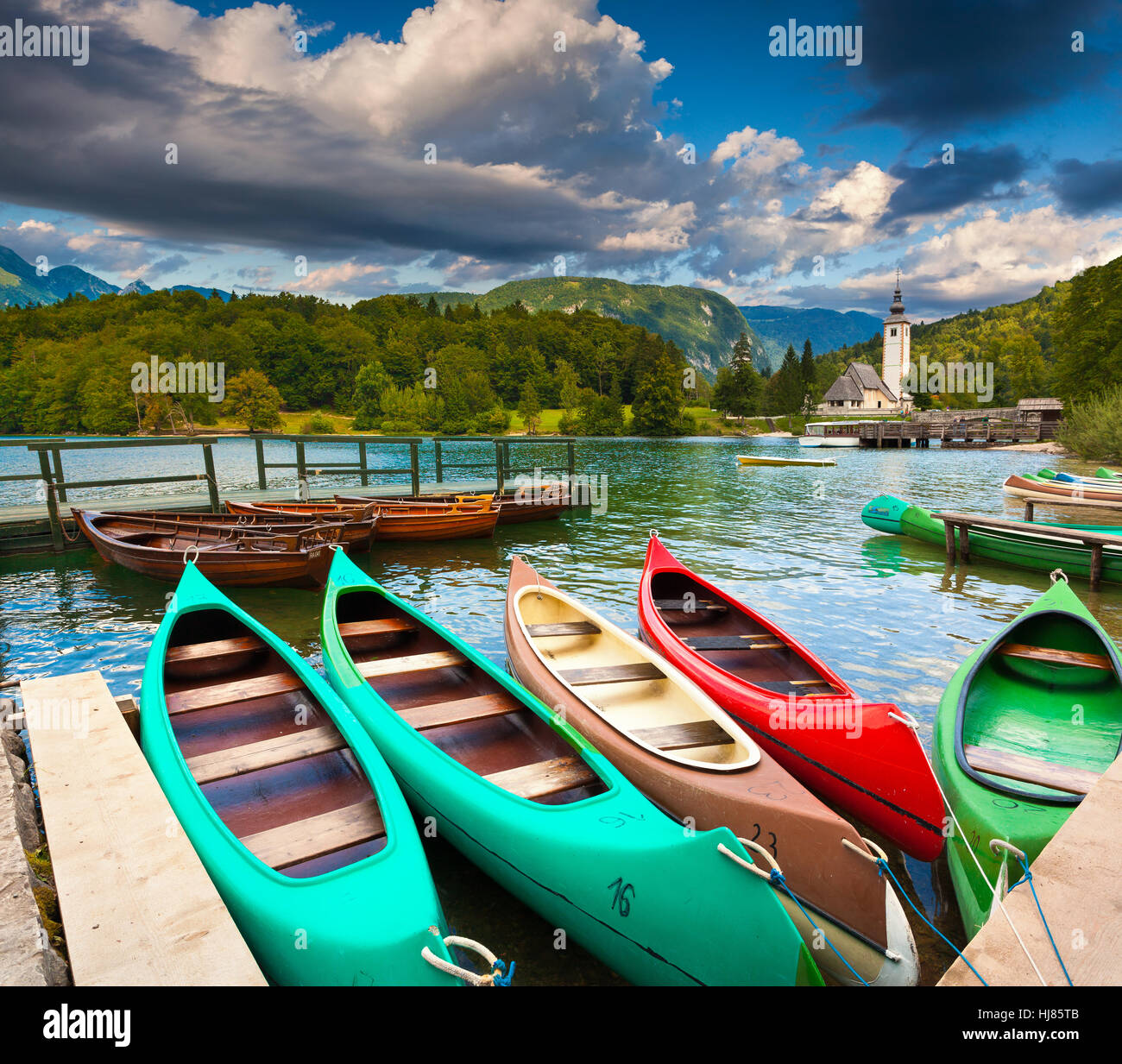 Bohinj See mit Booten und Kirche St. Johannes der Täufer, Nationalpark Triglav, Sloweniens. Stockfoto