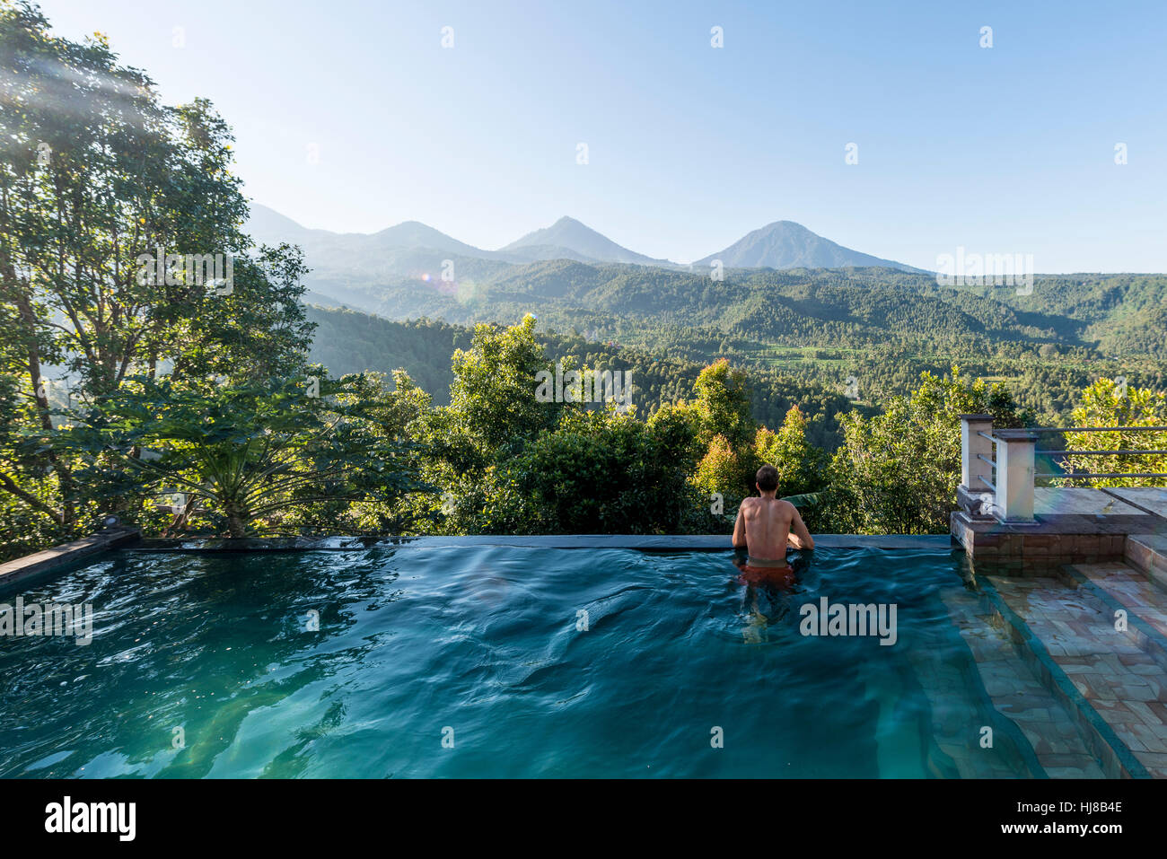 Mann mit Blick auf die Landschaft, Pool, Munduk, Bali, Indonesien Stockfoto