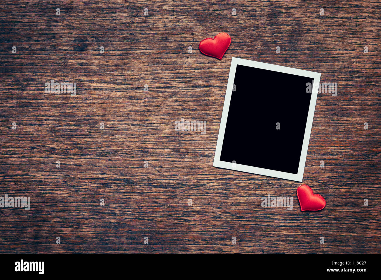 Leere Foto Frame und Red Heart auf Holz Hintergrund mit Raum. Stockfoto