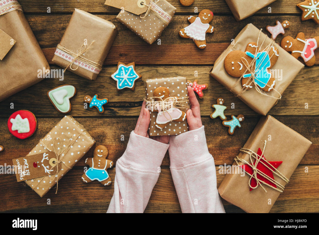 Mädchen hält Weihnachtsgeschenk mit Lebkuchenmann Stockfoto